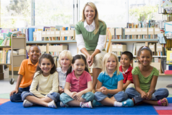 teacher and students sitting on the floor